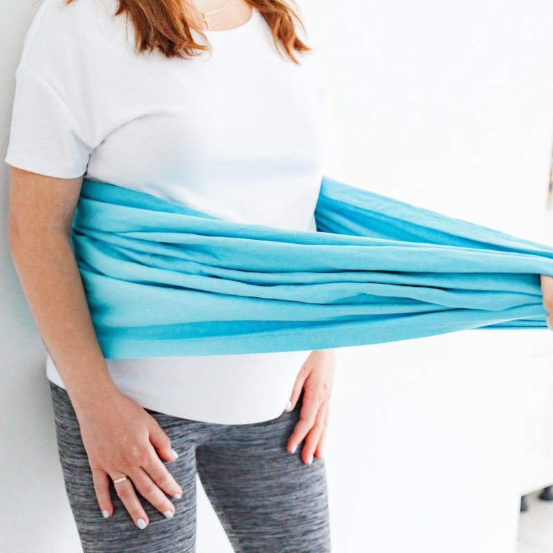 Doula making special exercises by rebozo with pregnant woman at home